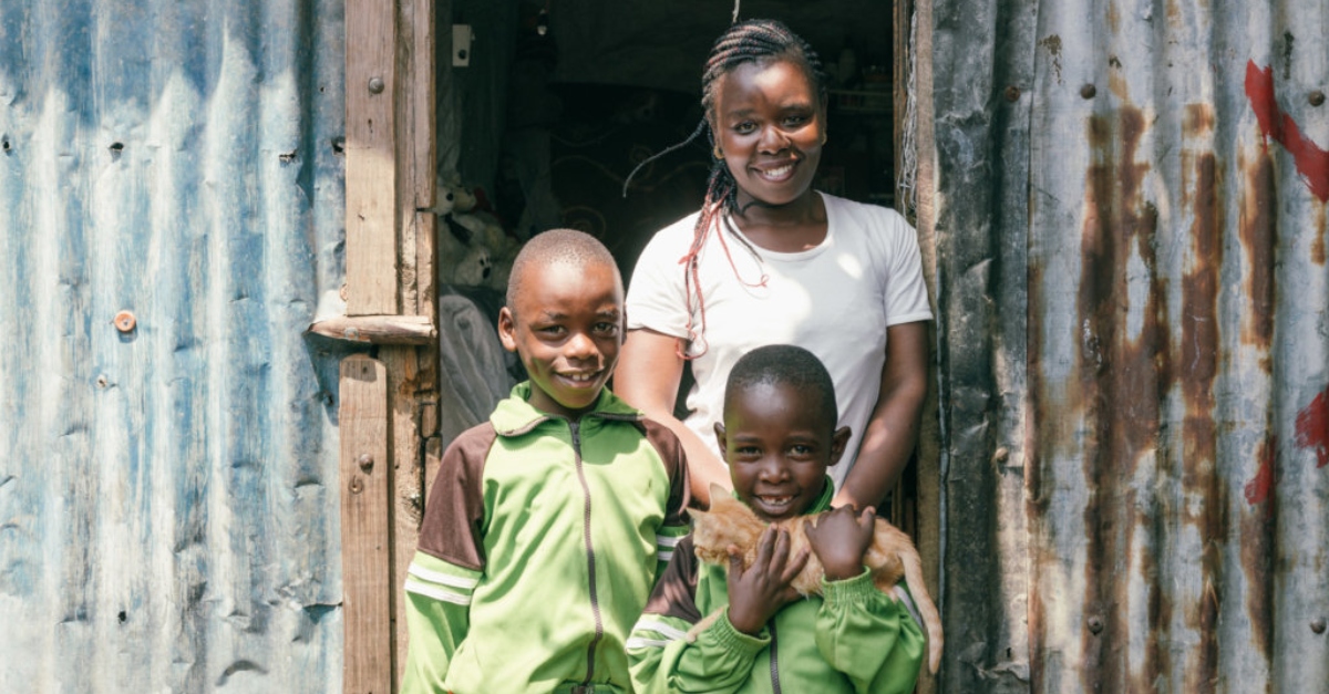 一位母亲带着两个孩子微笑;COVID-19人道主义援助