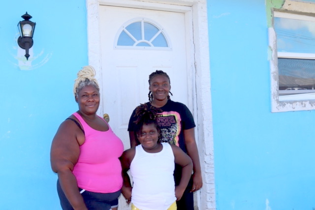 多里安飓风过后，一家人站在家门口
