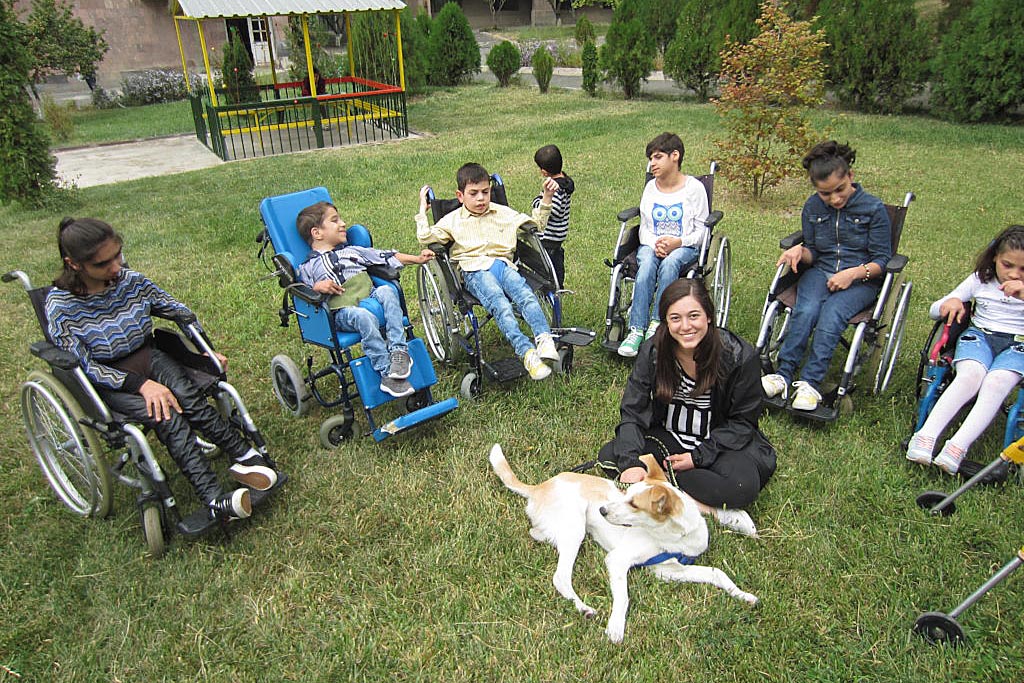 坐轮椅的孩子们围着治疗犬。有工作的狗帮助残疾儿童。