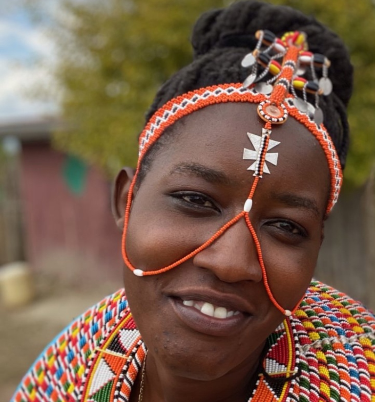 一个女人，脸上和脖子上戴着五颜六色的串珠首饰