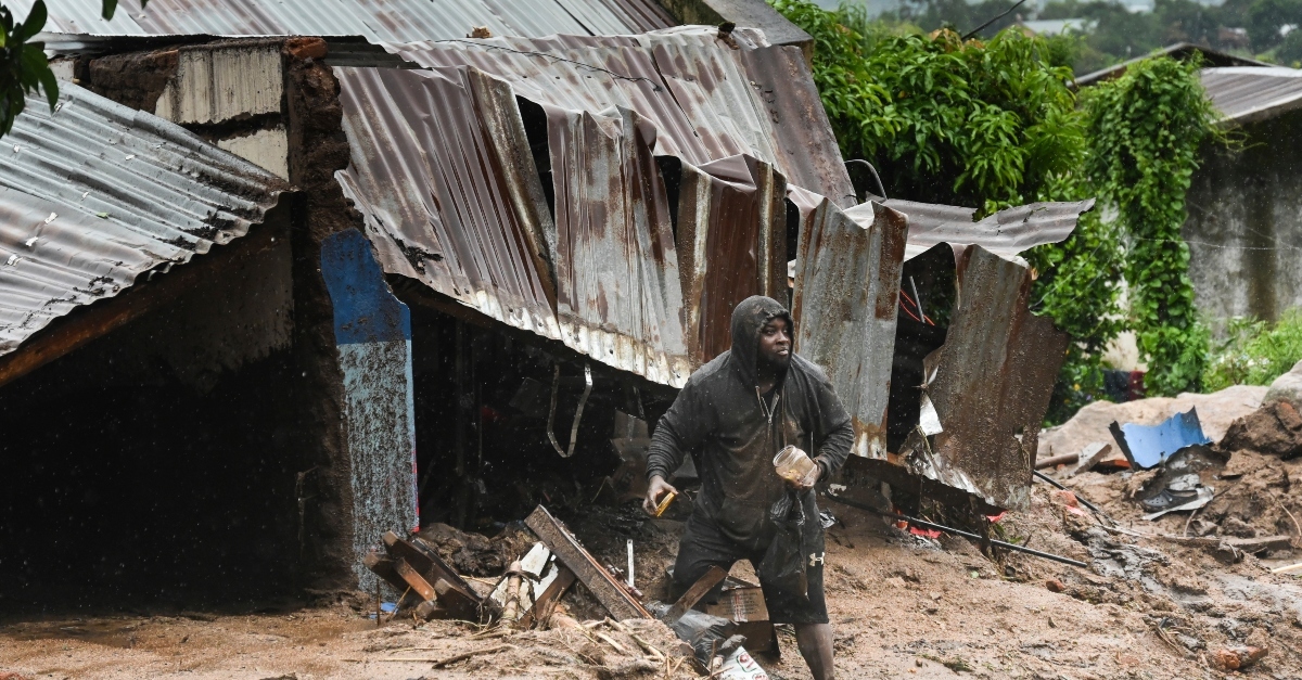 一个人站在被飓风弗雷迪摧毁的倒塌建筑前