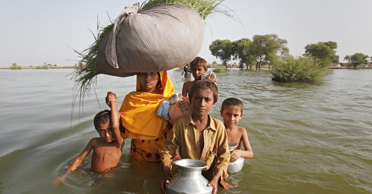 一家人在巴基斯坦洪水中涉水而过