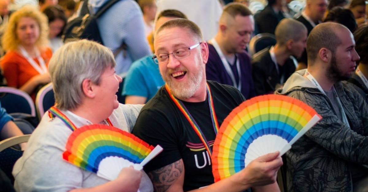 两人坐在会议厅举行彩虹颜色的粉丝”+平等